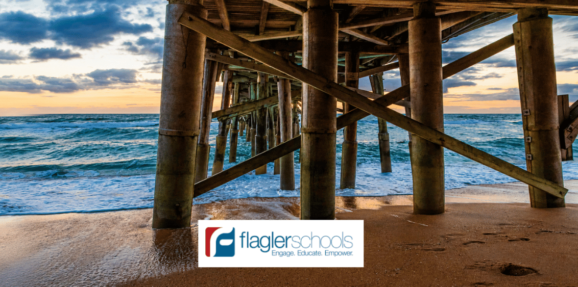 View from beneath the Flagler Beach Pier showing ocean waves rolling onto the shoreline at sunset, representing marine ecosystems, coastal environments, and ocean conservation efforts connected to Flagler Schools being named a Guy Harvey Conservation District in Flagler County, Florida.